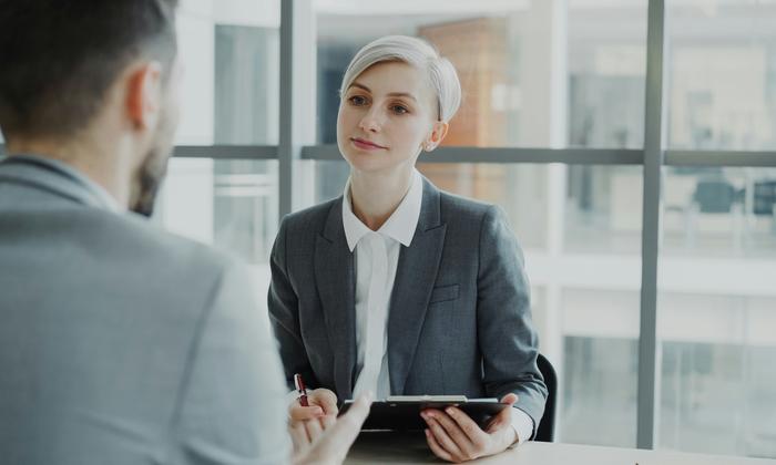 A woman interviewing a job candidate across a desk
