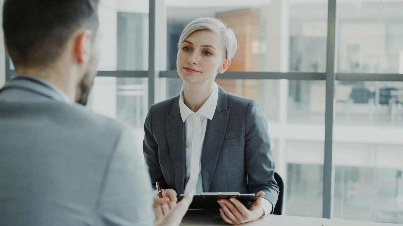 A woman interviewing a job candidate across a desk